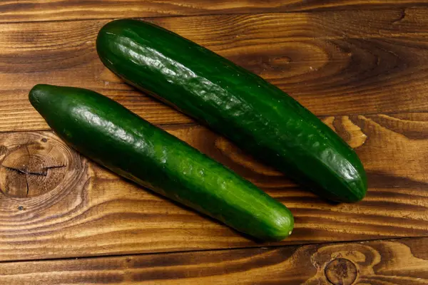 Twee verse komkommers op houten tafel — Stockfoto