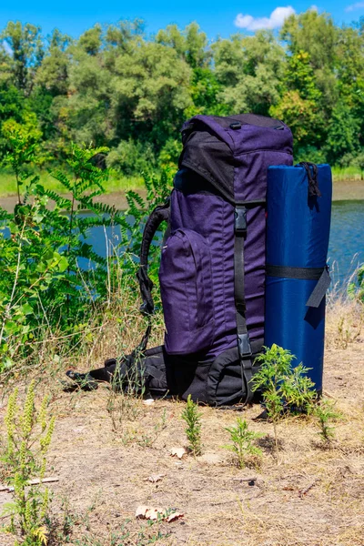 Mochila turística perto de um rio no verão. Conceito de caminhada — Fotografia de Stock