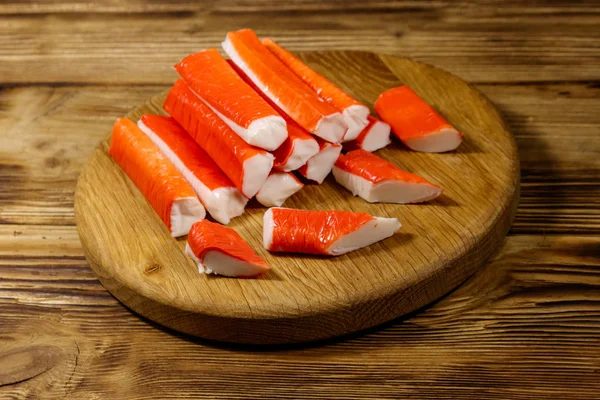 Crab sticks on cutting board on wooden table — Stock Photo, Image
