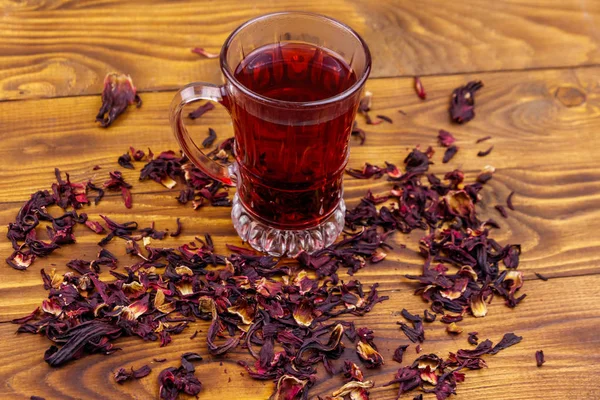 Glasschale mit rotem Hibiskustee (Karkade, Roselle) auf Holztisch — Stockfoto