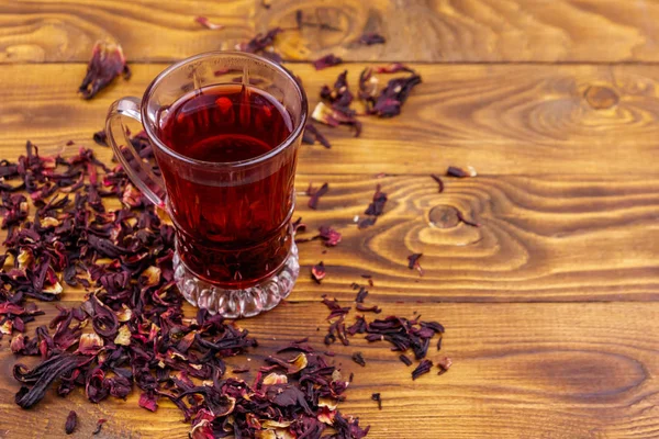 Glasschale mit rotem Hibiskustee (Karkade, Roselle) auf Holztisch — Stockfoto