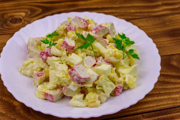 Salat mit Krabbenspießen, Mais, Chinakohl, Eiern und Mayonnaise auf Holztisch — Stockfoto