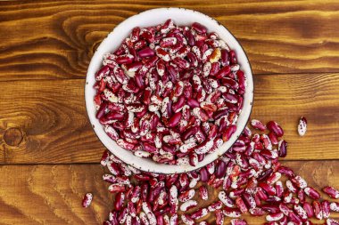 Ahşap masada beyaz eski emaye kase ham böbrek çekirdekleri 