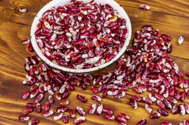 Ahşap masada beyaz eski emaye kase ham böbrek çekirdekleri 