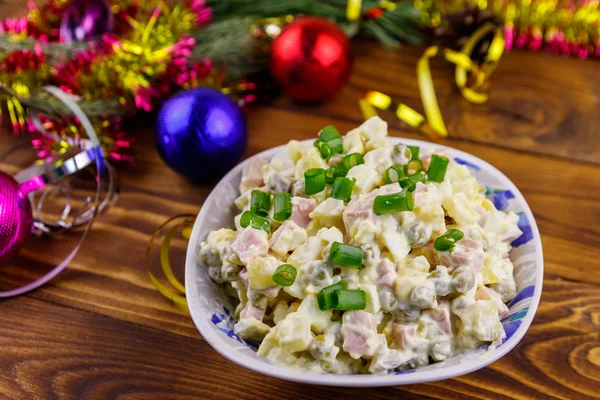 Traditional Russian festive salad Olivier and New Years decorations on wooden table — Stock Photo, Image