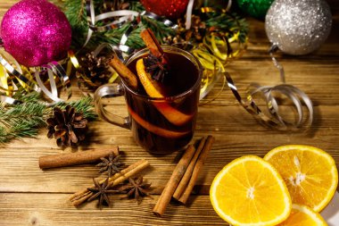 Baharatlı Noel şarabı ve ahşap masada Noel süsü.