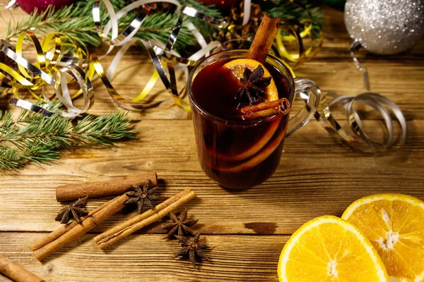 Christmas mulled wine with spices and Christmas decoration on wooden table — Stock Photo, Image