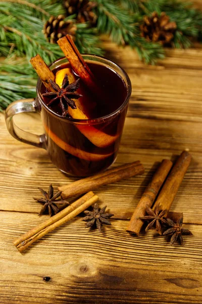 Christmas mulled wine with spices and fir tree branches and cones on wooden table — Stock Photo, Image