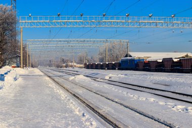 Güneşli kış gününde istasyonda karlı demiryolu rayları