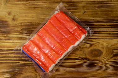 Yengeç, tahta masanın üzerindeki vakum paketine yapışır. Üstte görüntü