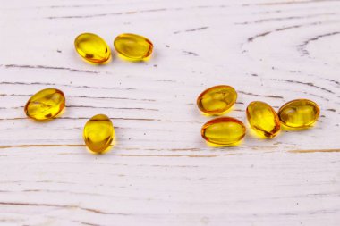 Beyaz ahşap bir masada Omega 3 hapları.