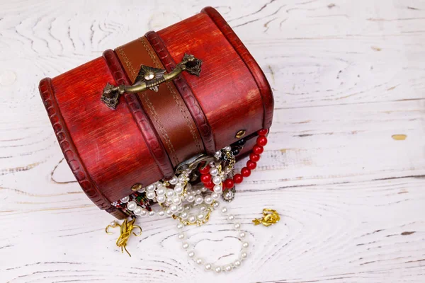 Vintage treasure chest full of jewelry and accessories on white wooden background — Stock Photo, Image