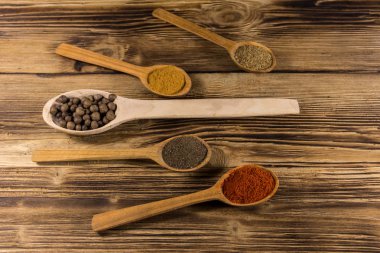 Tahta kaşıklar bir tablo içinde çeşitli baharatlar