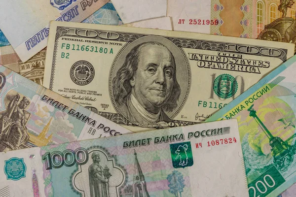 Сто долларов купюры на фоне российских рублей банкноты — стоковое фото