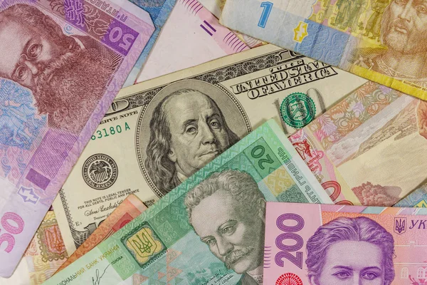 Ukrayna Hryvnia banknotlarının arka planında 100 dolarlık banknot