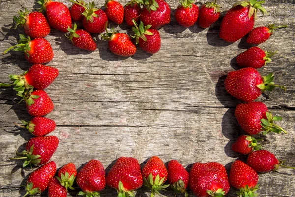 Taze kırmızı çilek çerçevesi ahşap masa üstünde fotokopi alanı manzaralı.