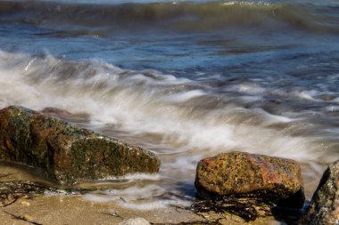 Kayaların üzerinden süzülen deniz dalgaları