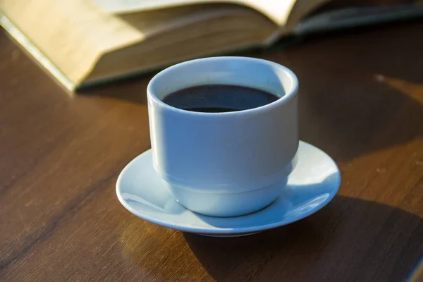 Tasse Kaffee und Buch auf Holztisch — Stockfoto