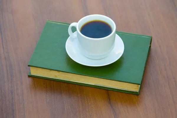 Taza de café y libro sobre mesa de madera — Foto de Stock