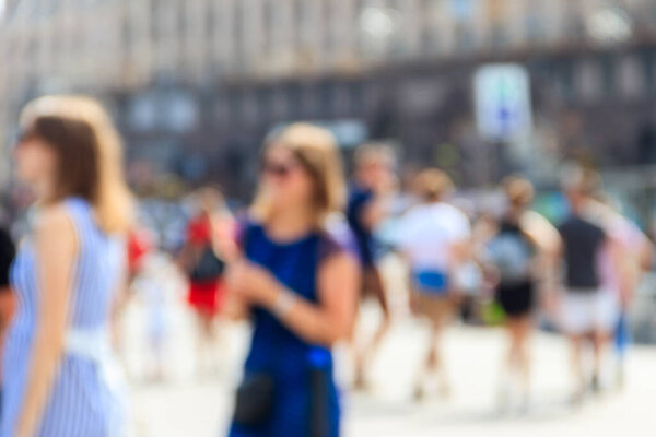 Blurred defocused abstract background of people walking on the city street. Unrecognizable faces