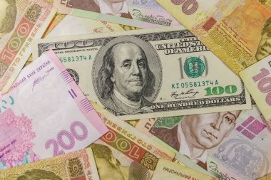 Farklı Ukrayna Hryvnia banknotlarının arka planında 100 dolarlık banknot