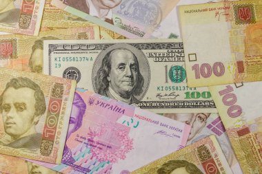Farklı Ukrayna Hryvnia banknotlarının arka planında 100 dolarlık banknot