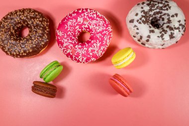 Pembe arka planda lezzetli çörekler ve kurabiyeler. Üst görünüm