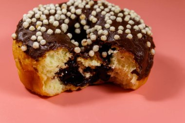 Pembe arka planda çikolatalı donut.