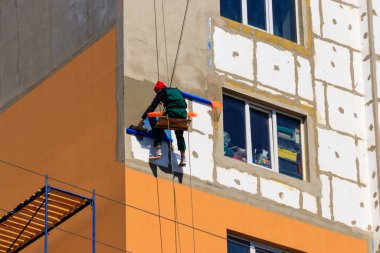 Yüksek katlı binanın köpük yalıtımı. İp girişi çalışıyor. Endüstriyel yükseklik kavramı