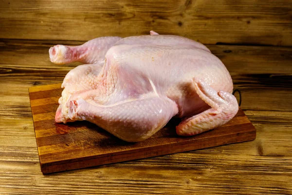 Raw whole chicken on a wooden table