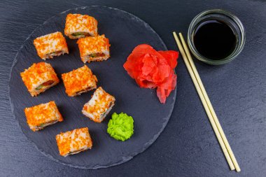 Suşi Philadelphia 'yı siyah bir levhada yuvarlıyor. Üst görünüm