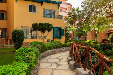 Bahçede yeşil ağaçlar ve çalılar olan patika ve manzara tasarımı