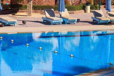 Yüzme havuzunun yanında şezlonglar. Spa, dinlenme, rahatlama, tatil, tatil