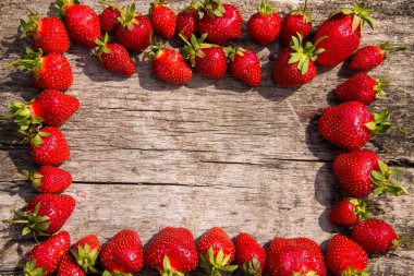 Taze kırmızı çilek çerçevesi ahşap masa üstünde fotokopi alanı manzaralı.