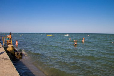 Genichesk, Ukrayna - 25 Ağustos 2017: bilinmeyen insanlar Azov Denizi'nde eğleniyor. Yaz tatillerini