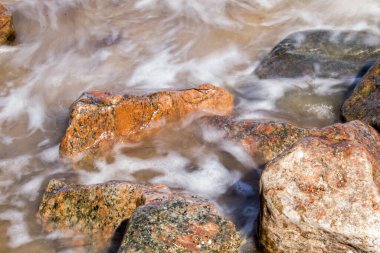 Kayaların üzerinden süzülen deniz dalgaları