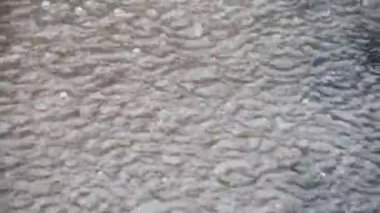 Sağanak yağış sırasında damlayan yağmur damlalarıyla su birikintisi