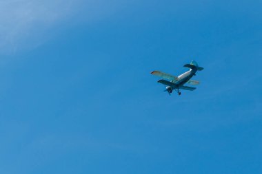 Mavi gökyüzünde uçan çift kanatlı uçak