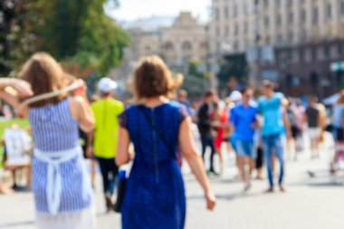 Şehir sokaklarında yürüyen insanların bulanık odaklı soyut arka planı. Tanımlanamayan yüzler