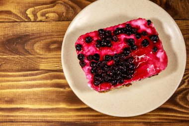 Ahşap masa üzerinde siyah frenk üzümü ile lezzetli cheesecake. Üstte görüntü