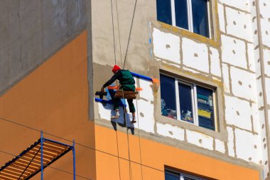 Yüksek katlı binanın köpük yalıtımı. İp girişi çalışıyor. Endüstriyel yükseklik kavramı