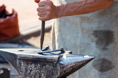 Demirci at nalı dövüyor.