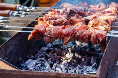 Metal şişte pişen ızgara kebap. Barbeküde kızartılmış et. Geleneksel doğu yemeği, şiş kebap. Kömür ve alevler üzerine ızgara, piknik, sokak yemekleri