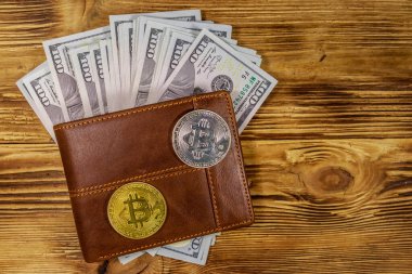 Ahşap arka plan üzerinde Amerikan yüz dolar faturaları ve bitcoins ile Cüzdan