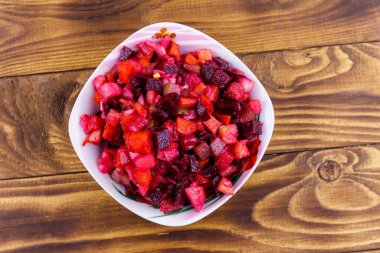 Pancar, havuç, patates, soğan ve ahşap masada salatalık turşusu ile geleneksel Rus salatası vinaigrette. Üstte görüntü