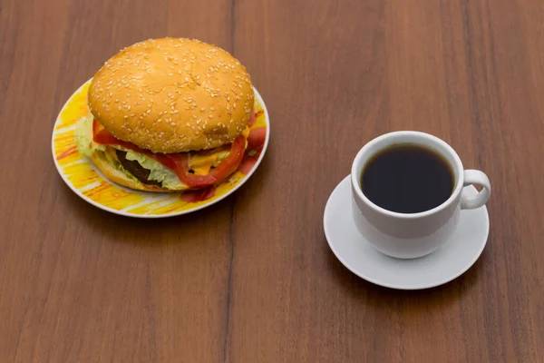おいしいハンバーガーと木製のテーブルの上のコーヒーカップ — ストック写真