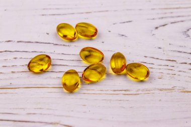 Beyaz ahşap bir masada Omega 3 hapları.