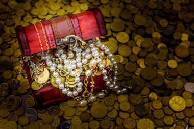 Altın sikke ve mücevherlerle dolu eski bir hazine sandığı.