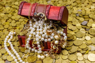 Altın sikke ve mücevherlerle dolu eski bir hazine sandığı.