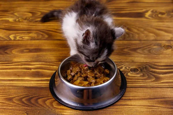 Kleines Kätzchen Frisst Sein Futter Aus Metallschüssel Auf Holzboden — Stockfoto
